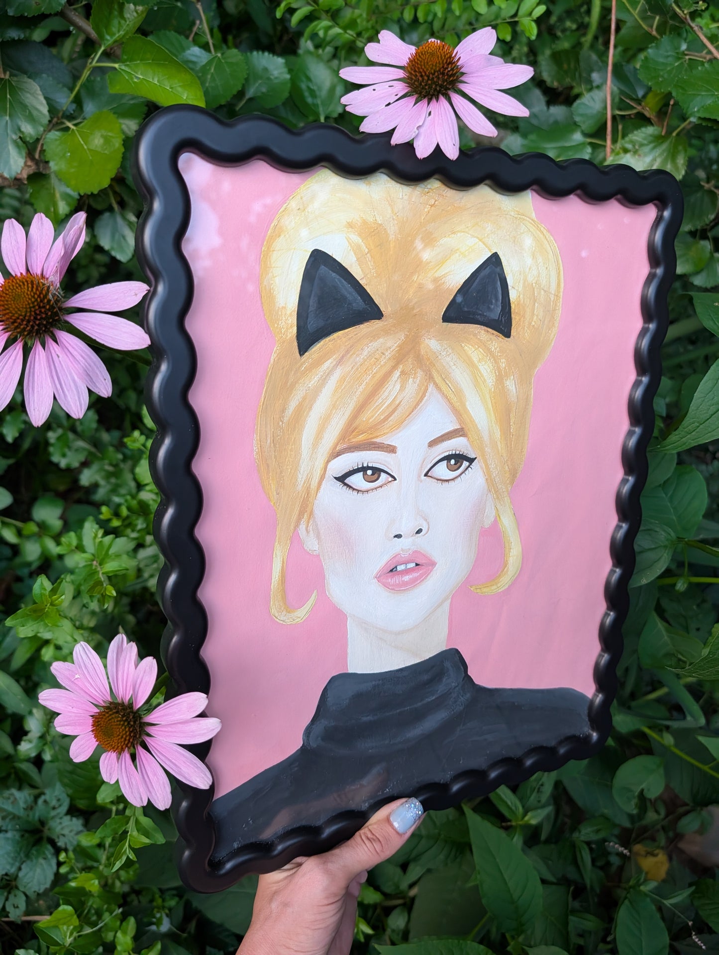 Original mixed media portrait of Brigitte Bardot with black cat ears and black turtleneck on pink background in black wavy frame