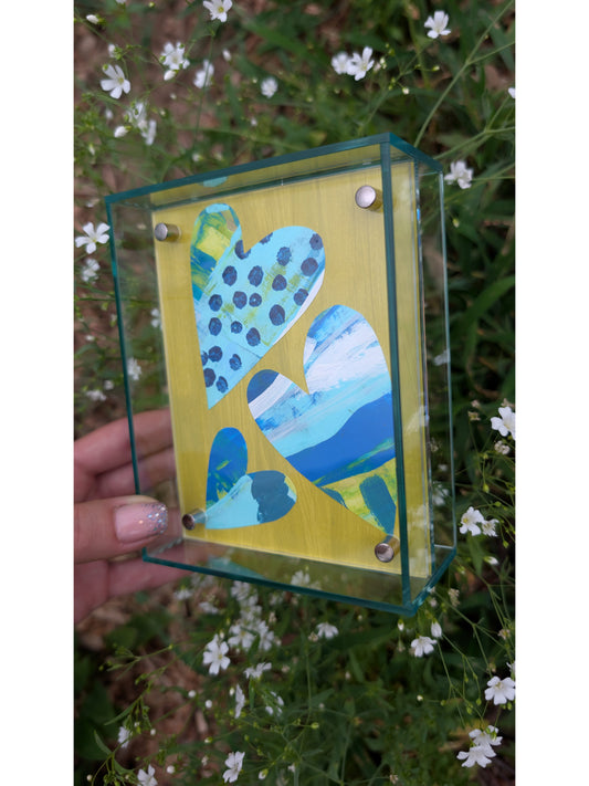 Small original heart collage with blue turquoise and white hand-painted paper hearts on lime green background in soft green acrylic float frame