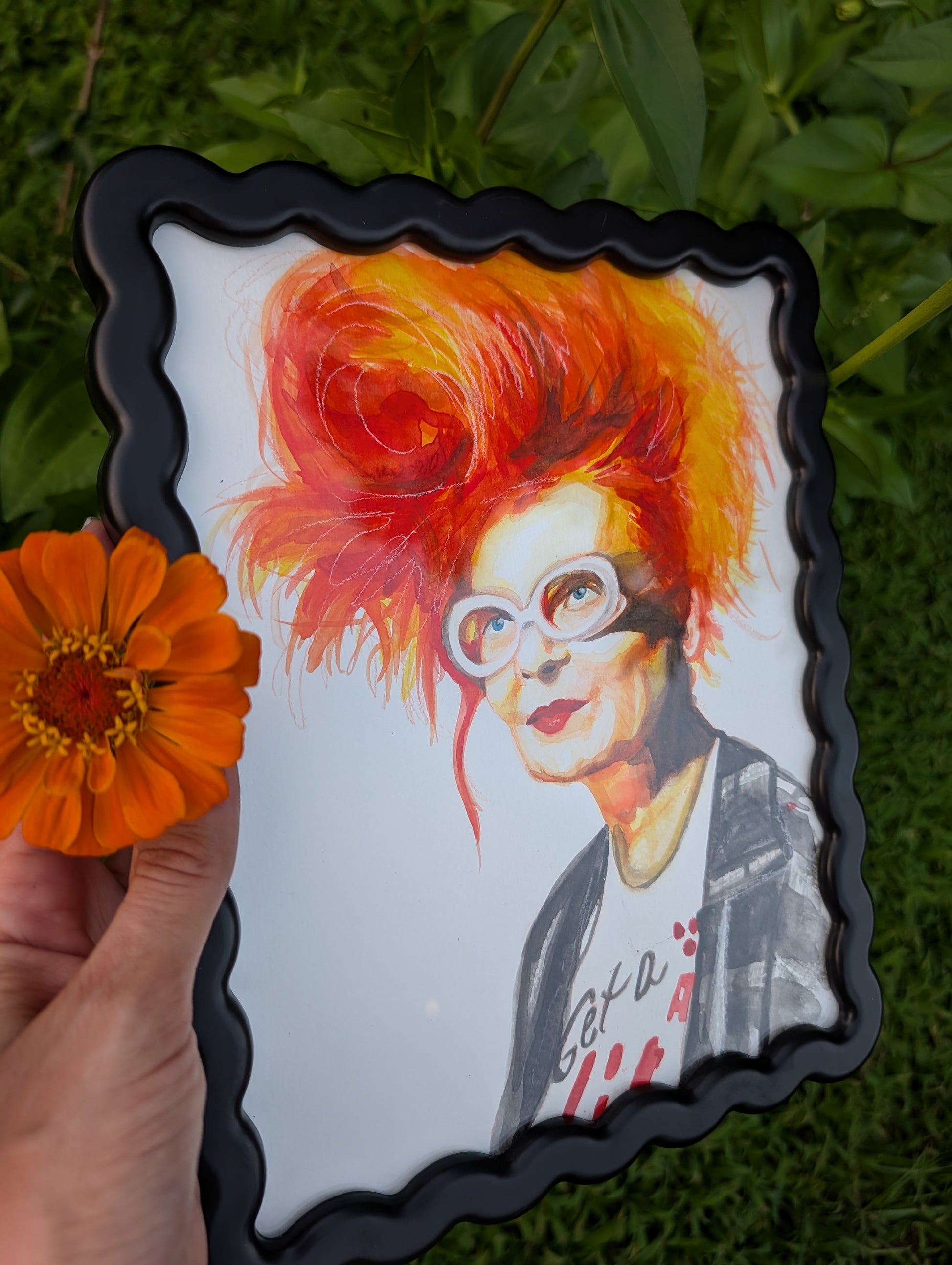 Original mixed media portrait of Vivienne Westwood with orange red hair white glasses and Get a Life Foundation shirt in black wavy frame