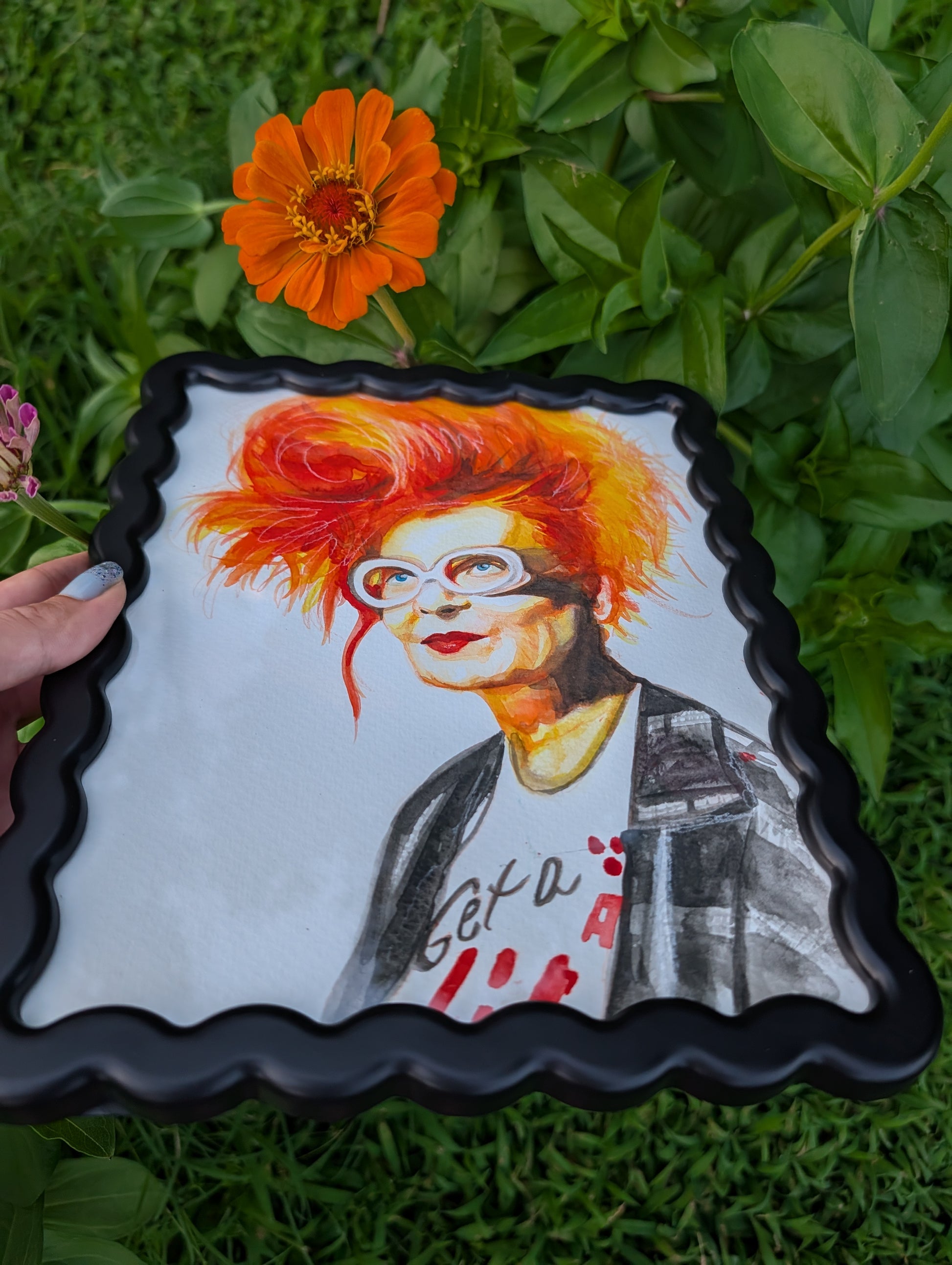 Original mixed media portrait of Vivienne Westwood with orange red hair white glasses and Get a Life Foundation shirt in black wavy frame