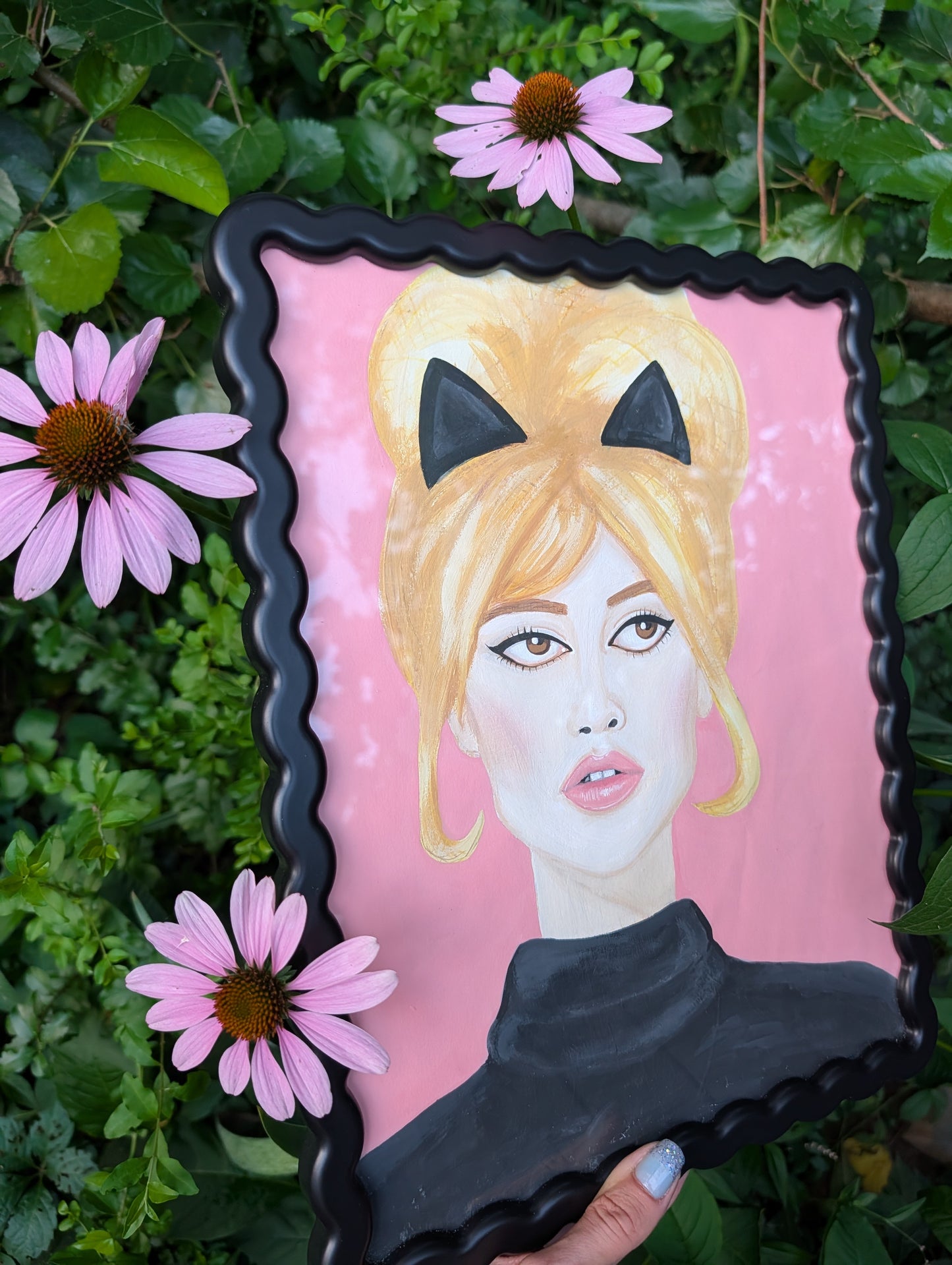 Original mixed media portrait of Brigitte Bardot with black cat ears and black turtleneck on pink background in black wavy frame
