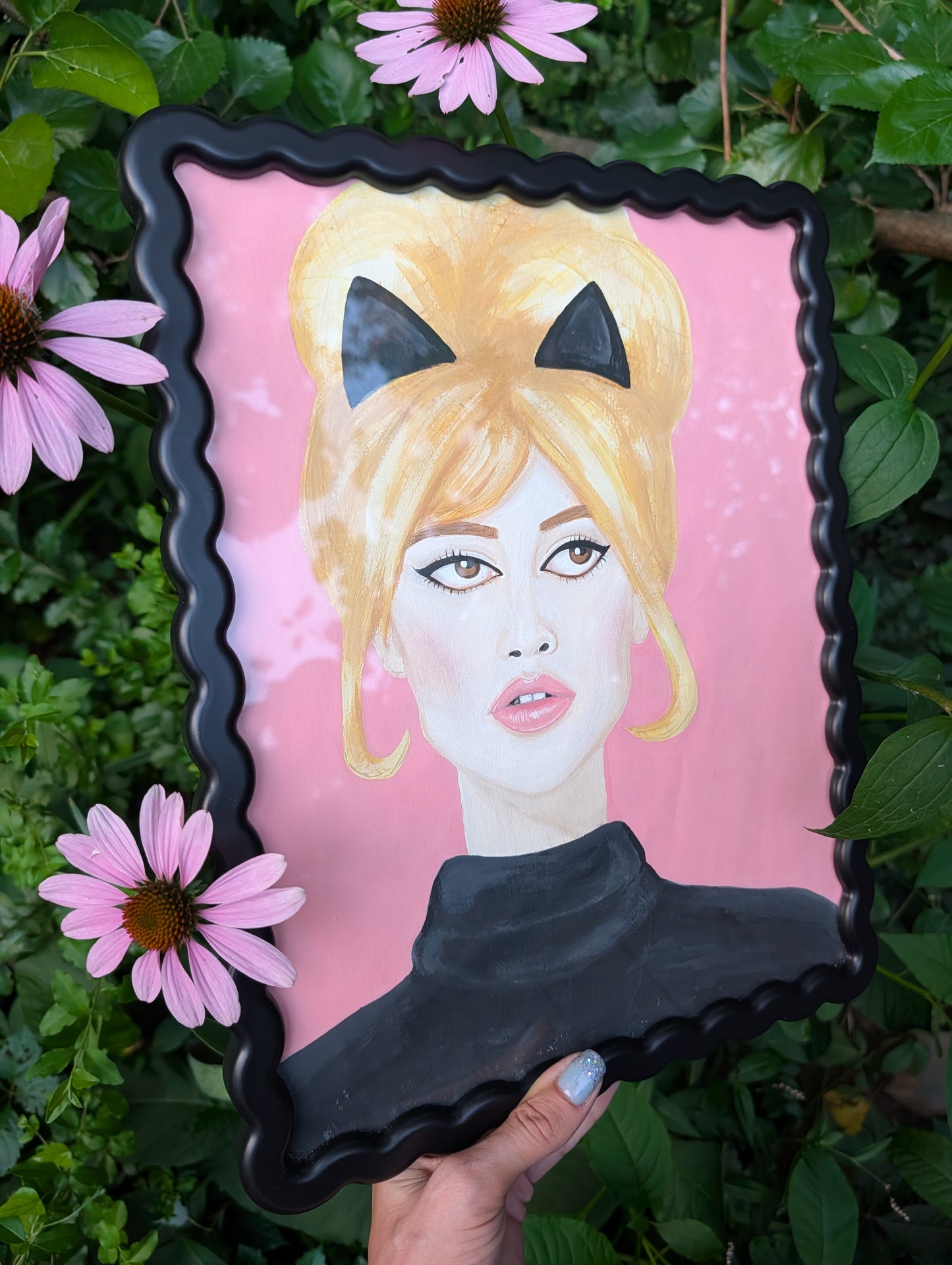 Original mixed media portrait of Brigitte Bardot with black cat ears and black turtleneck on pink background in black wavy frame