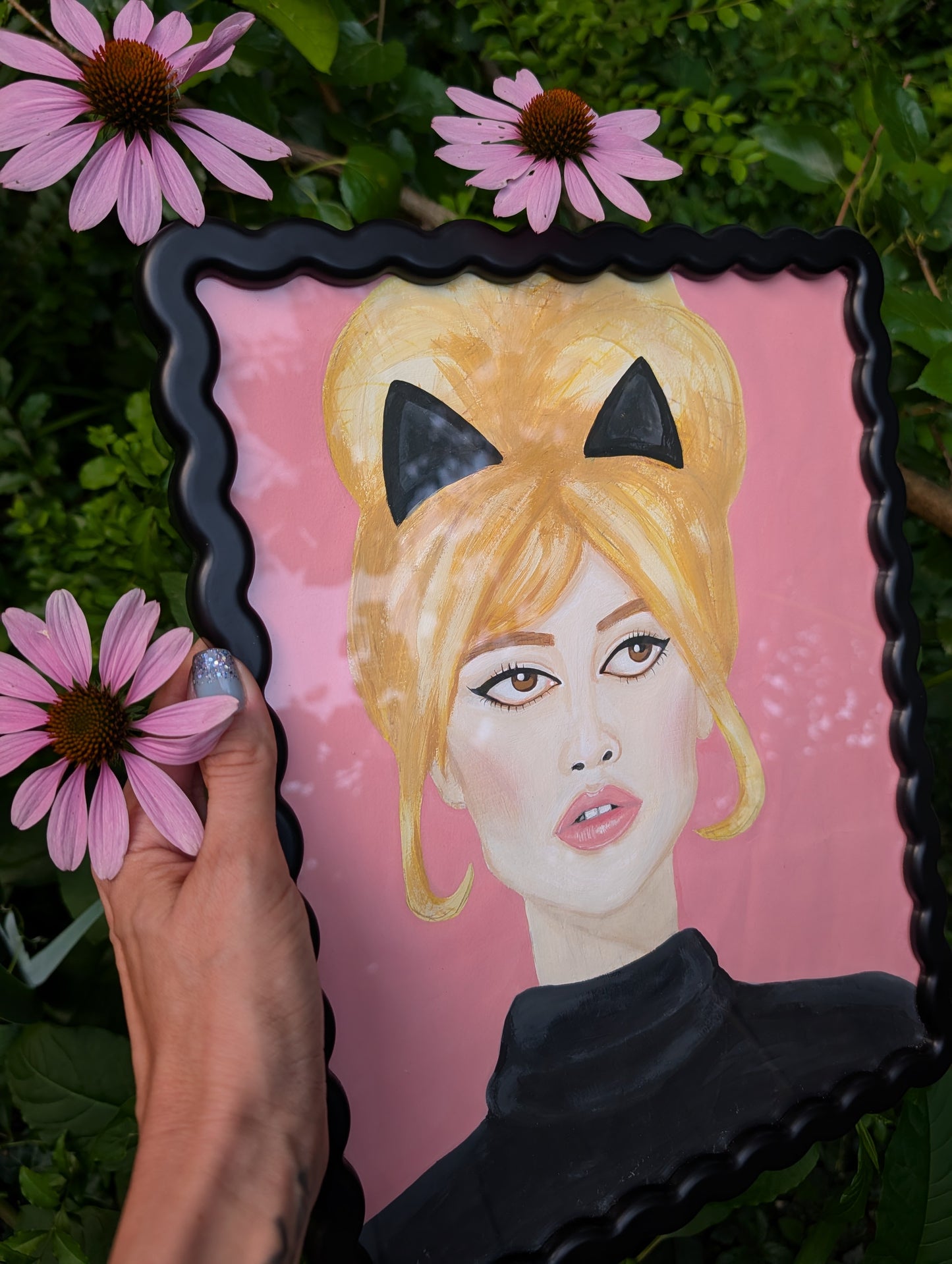 Original mixed media portrait of Brigitte Bardot with black cat ears and black turtleneck on pink background in black wavy frame