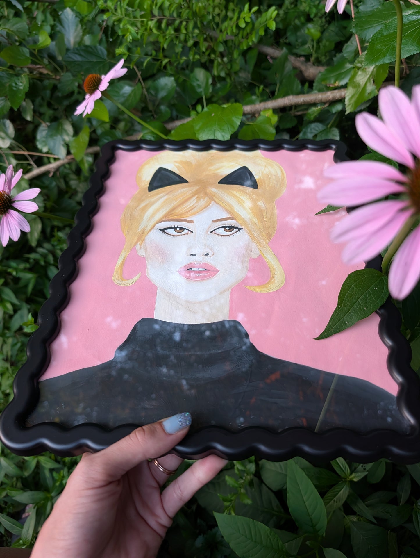Original mixed media portrait of Brigitte Bardot with black cat ears and black turtleneck on pink background in black wavy frame