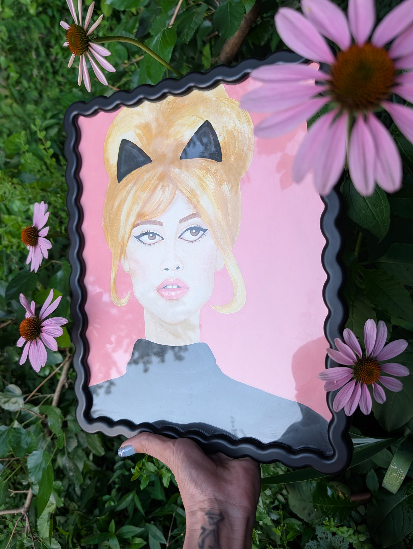 Original mixed media portrait of Brigitte Bardot with black cat ears and black turtleneck on pink background in black wavy frame