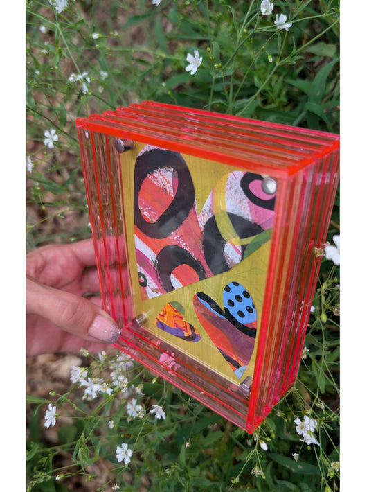 Small original heart collage with black pink and orange hand-painted paper hearts on lime green background floating in neon pink acrylic frame