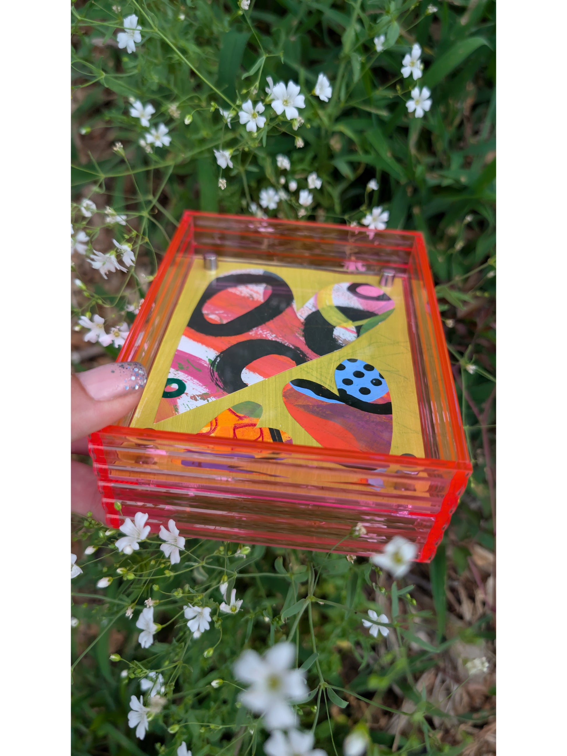 Small original heart collage with black pink and orange hand-painted paper hearts on lime green background floating in neon pink acrylic frame
