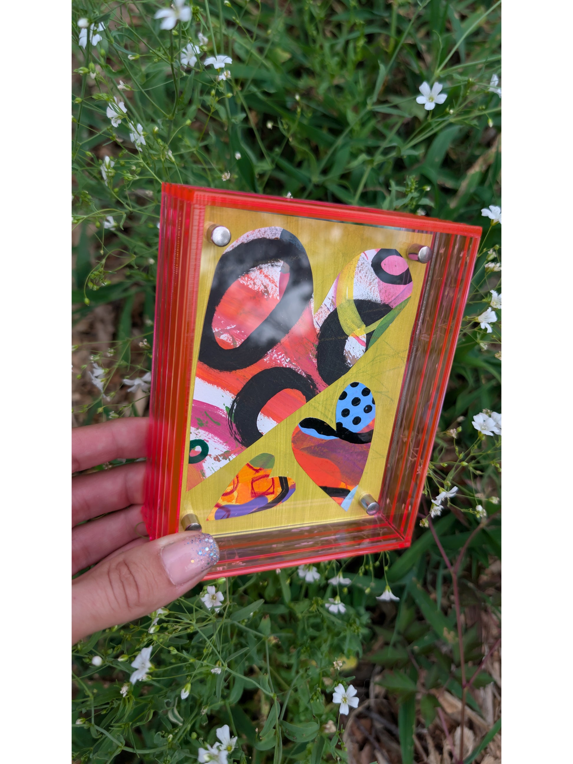 Small original heart collage with black pink and orange hand-painted paper hearts on lime green background floating in neon pink acrylic frame