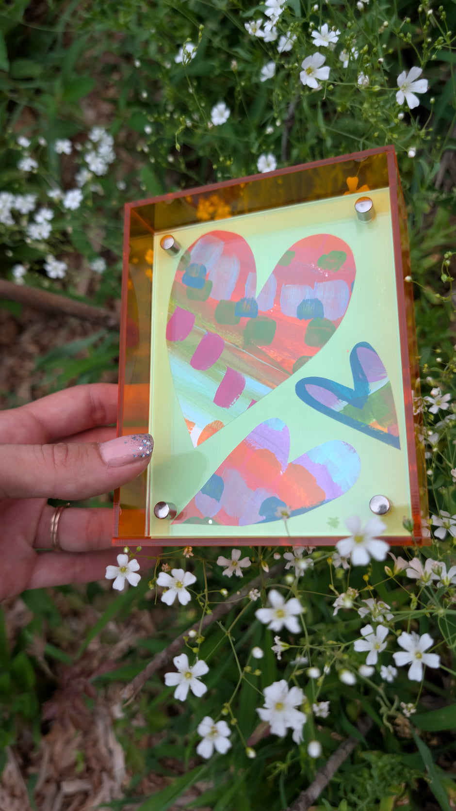 Small original heart collage with green pink and orange hand-painted paper hearts on mint green background in neon orange acrylic float frame
