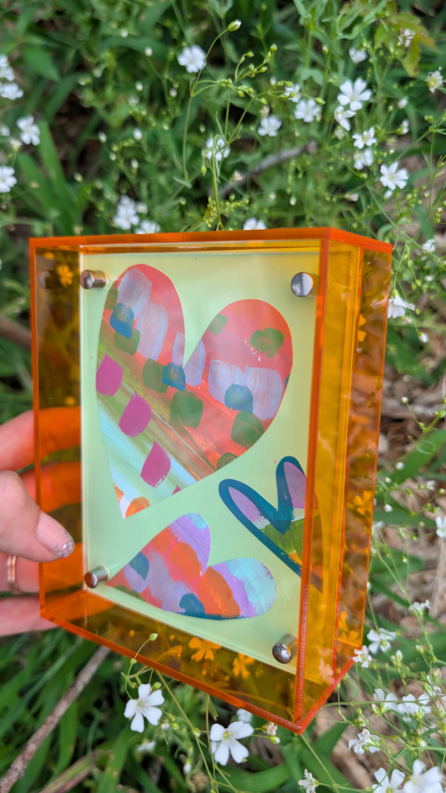 Small original heart collage with green pink and orange hand-painted paper hearts on mint green background in neon orange acrylic float frame