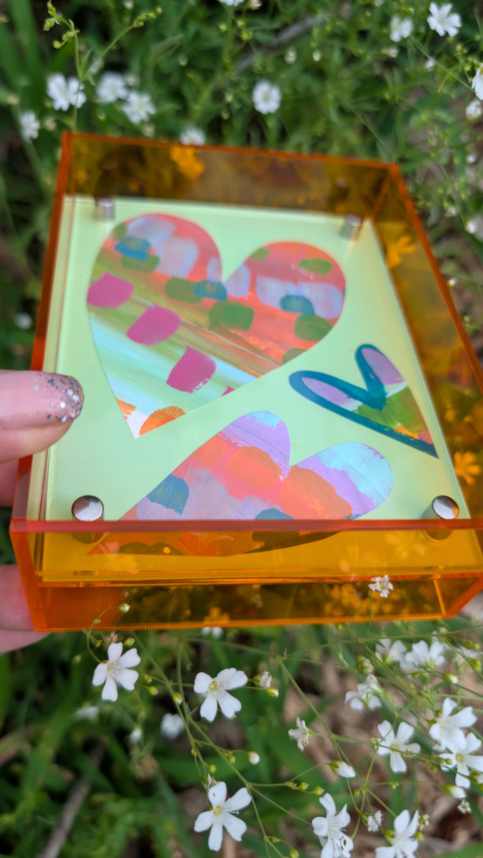 Small original heart collage with green pink and orange hand-painted paper hearts on mint green background in neon orange acrylic float frame