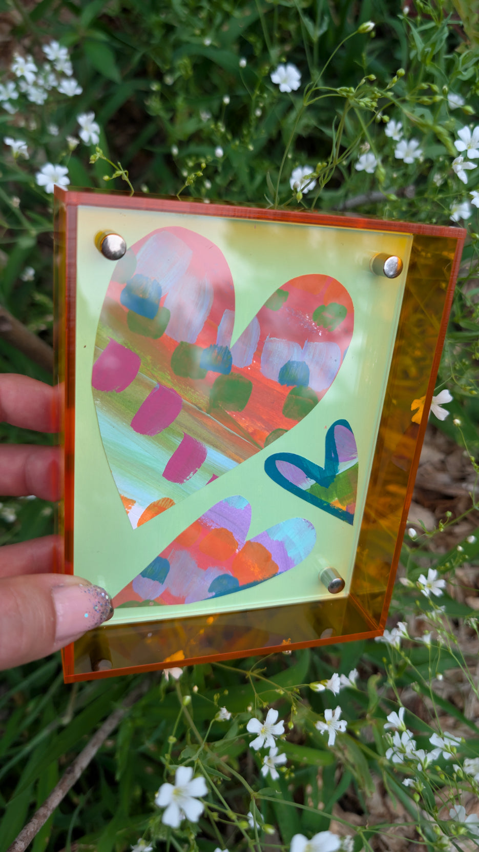 Small original heart collage with green pink and orange hand-painted paper hearts on mint green background in neon orange acrylic float frame