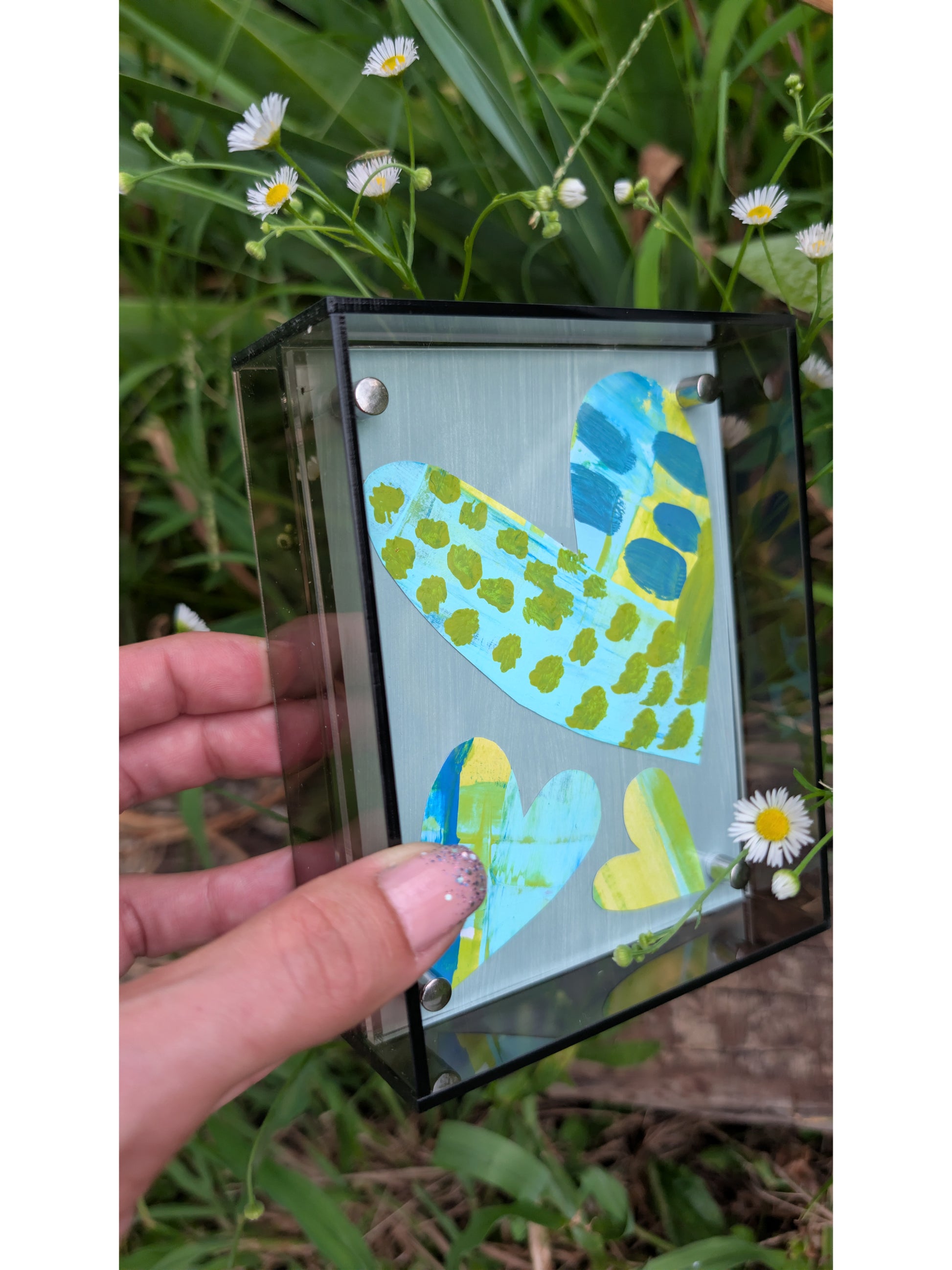 Small original heart collage with blue turquoise and green hand-painted paper hearts on gray background in gray acrylic float frame