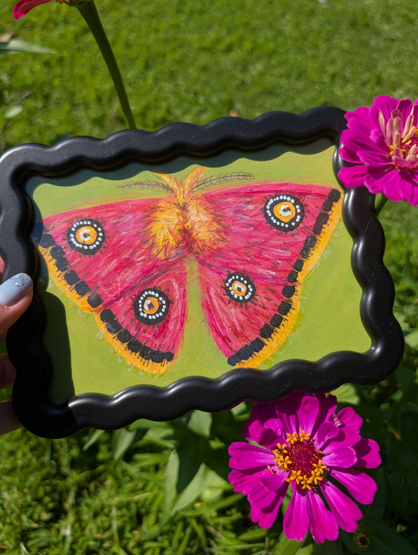 Original mixed media painting of pink moth with bold black white and yellow markings on lime green background in black wavy frame