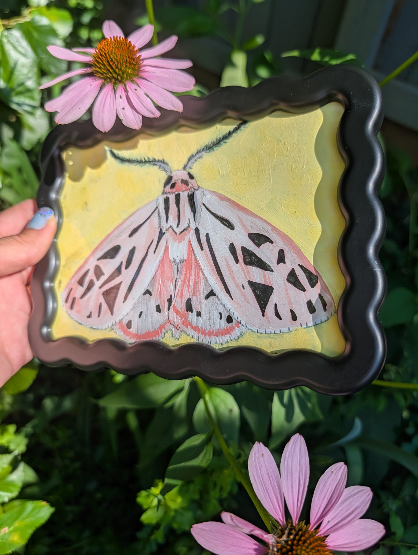 Original mixed media painting of pink moth with delicate black markings and fluffy antennae on soft yellow background in black wavy frame